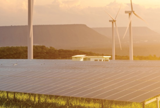 Rows of solar panels in the foreground with three wind turbines behind them, set against a backdrop of green hills and a warm, golden sunset sky, highlight the power of renewable energy harnessed through advanced sensors. by Standex Detect